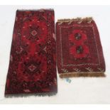 Two Eastern design mats, both with red grounds, 40ins x 19ins and 28ins x 19ins