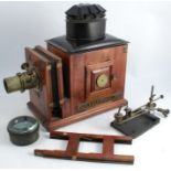 A 19th century mahogany and metal magic lantern, the brass lens engraved 10in Equi, the slide holder