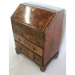 An Antique walnut bureau, the sloping fall front opening to reveal drawers, pigeon holes and a well,