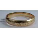 A 9ct gold hinged bangle, with engraved decoration to one half, weight 16.7g