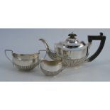 A matched silver three piece bachelors tea set, with gadrooned lower body, Birmingham 1899 and 1903,