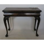 A 19th century mahogany fold over side table, the rectangular fold over top supported by pull out