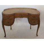 A walnut kidney shaped dressing table, with gilt metal gallery back, fitted with five drawers,