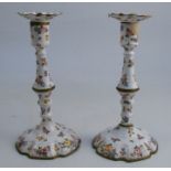 A pair of 19th century Bilston enamel candlesticks, decorated with flowers to a white ground, af,