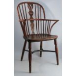 A 19th century yew wood hoop back Windsor armchair, with a pierced central vase and crinoline