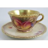 A Royal Worcester tea cup and saucer, the cup decorated to the interior and the saucer with fruit to