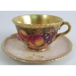 A Royal Worcester tea cup and saucer, the cup decorated to the interior and the saucer with fruit to