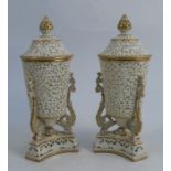 A pair of Grainger's Worcester reticulated covered vases, the cylindrical body on three scroll