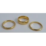 A 22 carat gold wedding ring, together with two others, 12g gross