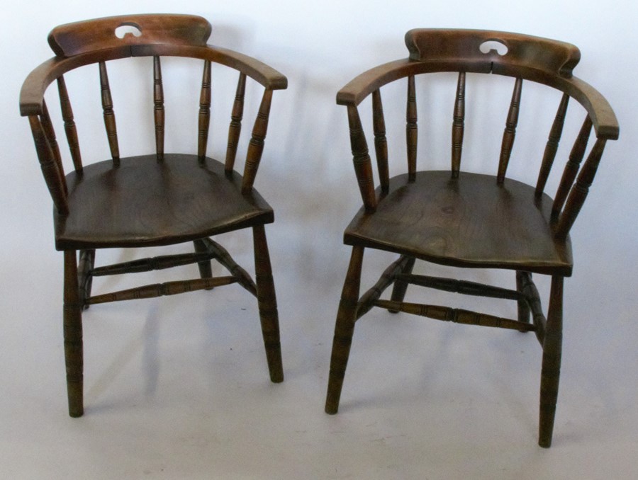 A pair of captain armchairs, with spindle backs, turned legs united by turned stretchers