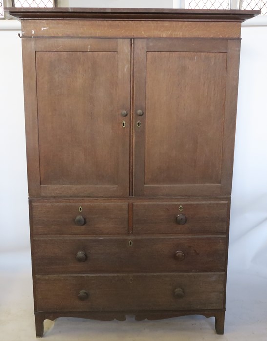 A 19th century oak linen press, the cupboard fitted with shelves, the base with two short over three