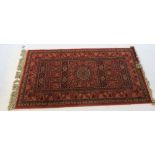 A modern Eastern design rug, decorated with flower heads, 59ins x 33ins