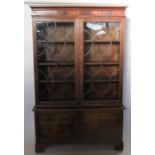 A 19th century mahogany display cabinet, with a pair of glazed doors with fancy glazing bars, over a