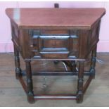 A 17th century style oak credenze table, the octagonal folding top supported by a gateleg action,