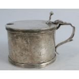 A silver mustard pot, with scroll thumb piece and ribbed edges, London 1932, weight 6oz, together