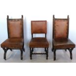 A pair of oak framed chairs, with carved lion masks to the top rail, upholstered backs and seats, on