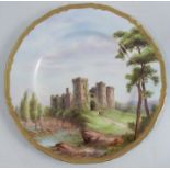 A Royal Worcester plate, decorated with a view of Raglan castle, by Ayrton, diameter 10.