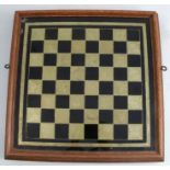 An oak framed wall mirror and games board, the one side with mirror the reverse with black and