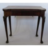 A 19th century mahogany fold over games table, having a shaped rectangular top, the games surface