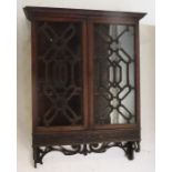 A mahogany wall cabinet, the pair of glazed doors with fancy glazing bars, over a blind fret cut