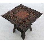 An Eastern mahogany carved square table, the top heavily carved with flowers and leaves, on a carved