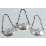 A set of three 18th century silver bottle tickets, of curved form with fleur de lye and engraving,