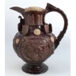 An Essex pottery Castle Hedingham jug, the brown ground having various panels surrounded by