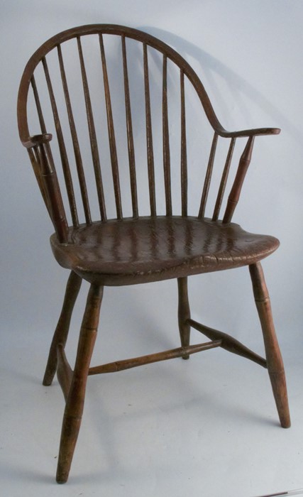 A primitive antique Windsor armchair, with some simulated bamboo spindles, showing signs of original