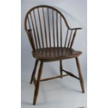 A primitive antique Windsor armchair, with some simulated bamboo spindles, showing signs of original
