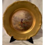 A Royal Worcester plate, decorated with a large central panel of pheasants in a glade, to a deep