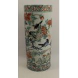 An oriental cylinder shaped vase, decorated with birds and foliage to an iron red ground and blue