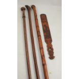 Three wooden walking sticks, the one carved with a fist to the pommel, one with Oriental decoration,