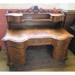 A burr walnut writing desk, having cross banded serpentine shaped front, with galleried shelf and
