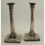 A pair of silver candlesticks, of column form, decorated with swags, rosettes and harebells,