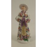 A continental figure of a Mandarin wearing a cloak, decorated with flowers, cross swords marks and