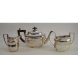 A three piece silver tea set, engraved with a crest, Chester 1909, maker George Nathan & Ridley