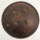 An 18th/19th century Indian or Ottoman leather shield, of convex form with six metal bosses,