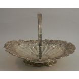 An oval silver basket, with swing handle, the pierced border decorated with flowers and scrolls,