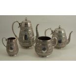 A silver four piece tea and coffee set, each piece heavily decorated in the Indian style, London
