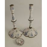 A pair of 19th century Staffordshire enamel candlesticks, decorated with blue flowers on a white