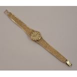 Omega, a lady's 9 carat gold mechanical bracelet watch, the round gilt dial with gilt black batons
