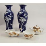 A pair of oriental baluster vases, decorated with prunus to a blue ground, height 9.75ins,