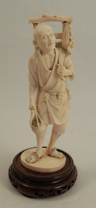 A 19th century carved ivory figure, of an Eastern man with harvested crops on his back, signed to