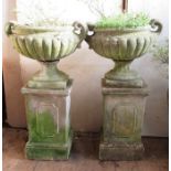 A pair of garden concrete urns, on rectangular columns, height 42ins