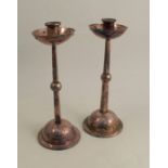 A pair of Arts and Crafts silver plated candlesticks, with circular sconce, height 11.25ins