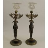A pair of 19th century Regency style cast bronze candlesticks, with Egyptian figures supporting