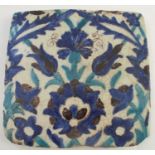 An Antique Iznik style tile, decorated with flower heads in turquoise and blues, 8.5ins x
