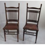 A pair of Arts and Crafts style oak single chairs, with ball and spindle back, raised on turned