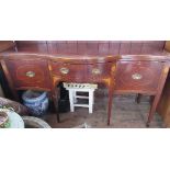 A late 19th century serpentine shaped sideboard, fitted with a cupboard and a drawer, flanking a