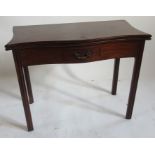 A Georgian mahogany serpentine shaped fold over tea table, fitted with a frieze drawer and raised on